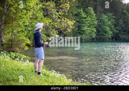 Der Mensch fischt am See in einer wunderschönen grünen Natur Stockfoto