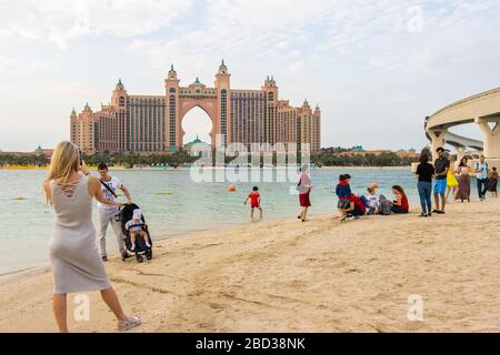 Dubai, VAE - 14. Dezember 2019: Strand mit Touristen im Hintergrund des Hotels Atlantis. Stockfoto