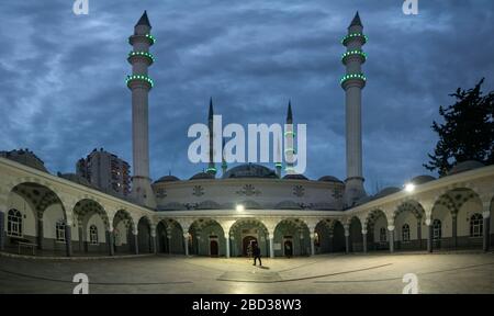 Menschen, die in einer bewölkten Nacht in eine türkische Moschee eintreten Stockfoto