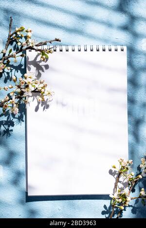 Leeres Notizbuch mit Schatten eines blühenden Baumes Stockfoto