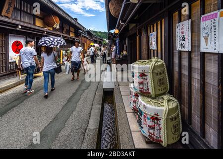 Takayama, Japan, August 2019 - die malerische Straße Sannomachi in der Takayama-Altstadt mit Sake Barrels vor einem traditionellen Haus Stockfoto