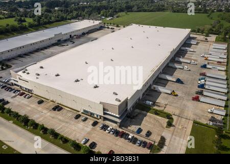 Trucks werden im McLane Global Distribution Center eingesetzt, wo Mitarbeiter Lebensmittelboxen für Studenten in ländlichen Schulen packen, die aufgrund der COVID-19-Pandemie am 26. März 2020 in Houston, Texas geschlossen sind. McLane Global stellt zusammen mit dem US-Landwirtschaftsministerium, PepsiCo und Baylor Collaborative fast 1.000.000 Mahlzeiten pro Woche für bedürftige Studenten bereit. Stockfoto
