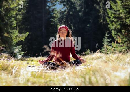 Junges Mädchen meditiert im Wald in lotus-position. Konzept - Einheit mit der Natur und innere Harmonie Stockfoto