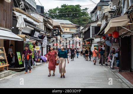 Miyajima, Japan, August 2019 - Touristen und Einheimische schlendern die Straße Omotesando in Miyajima voller Geschenkeladen Stockfoto