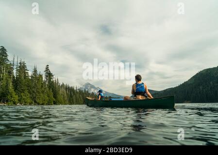 Ein junges Mädchen fährt mit ihrem Vater in einem Kanu auf dem Lost Lake in Oregon. Stockfoto