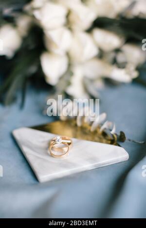 Diamantringe und Eheringe. Auf dem blauen Hintergrund. Stockfoto