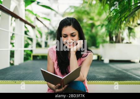 Schöne Agraringenieurin, die ihre Notizen im Gewächshaus liest Stockfoto