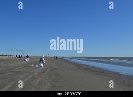 Schwarze Frauen in weißen Gewändern beten am Strand von Galveston, Texas Stockfoto