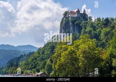 Mittelalterliche Burg auf dem Felsen über dem Bleder See, Alpine Berge im Hintergrund. Bled, Slowenien Stockfoto