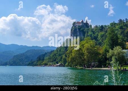 Mittelalterliche Burg auf dem Felsen über dem Bleder See, Alpine Berge im Hintergrund. Bled, Slowenien Stockfoto