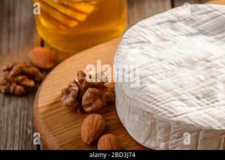 Brie Käse serviert mit Mandeln, Walnüssen und Honig Stockfoto
