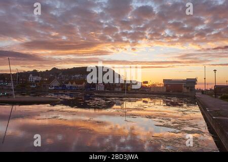 Hastings, East Sussex, Großbritannien. April 2020. Sonnenaufgang hinter dem Life Boat House über dem Bootssee. Stockfoto