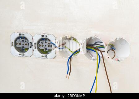 steckdosen und Kabel mit 220 v an beigefarbenen Wänden gemäß eu-Normen. Stockfoto