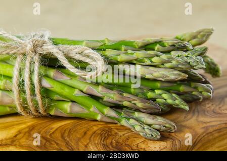Frischer junger Asparagus-Nahkampf. Spargel auf Holzbrett. Stockfoto
