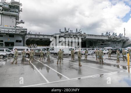 Seabees, die dem Naval Mobile Construction Battalion (NMCB) 1 und NMCB 5 zugeordnet sind, koordinieren den Transport von Sailors, die dem Flugzeugträger USS Theodore Roosevelt (CVN 71) zugeordnet sind, die negativ auf COVID-19 getestet haben und asymptomatisch vom Marinestützpunkt Guam an die Regierung von Guam und militärisch genehmigte kommerzielle Unterkünfte am 3. April sind. 2020. Seeleute müssen mindestens 14 Tage in Quarantäne in ihrer zugewiesenen Unterkunft bleiben, gemäß der DoD-Richtlinie und der Anordnung des Gouverneurs. Stockfoto