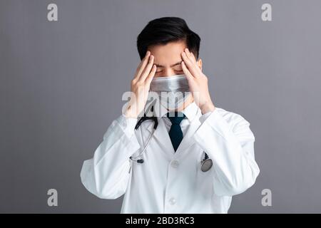 Stress und müde junge Ärzte tragen medizinische Maske Stockfoto