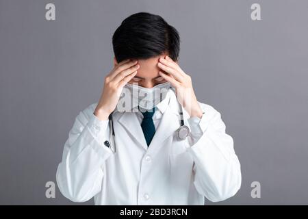 Stress und müde junge Ärzte tragen medizinische Maske Stockfoto