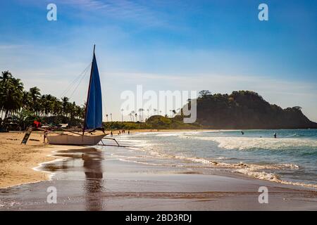 Ein segelboot auf dem Sand von Nacpan Beach an einem sonnigen Nachmittag in El Nido, Philippinen Stockfoto