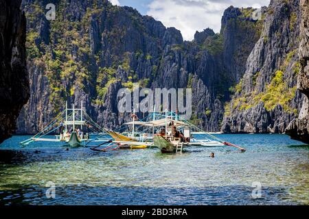 Inselhopper-Touristenboote in einer von Klippen umrahmten Lagune auf Shimizu Island in der Bacuit Bay bei El Nido, Palawan, Philippinen Stockfoto