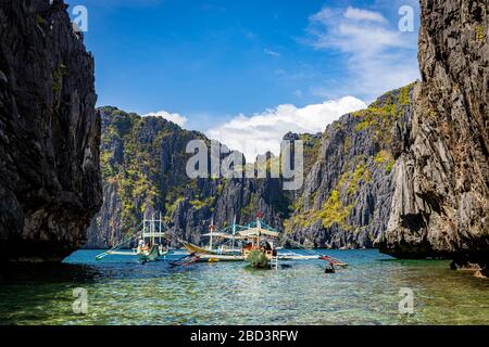 Inselhopper-Touristenboote in einer von Klippen umrahmten Lagune auf Shimizu Island in der Bacuit Bay bei El Nido, Palawan, Philippinen Stockfoto