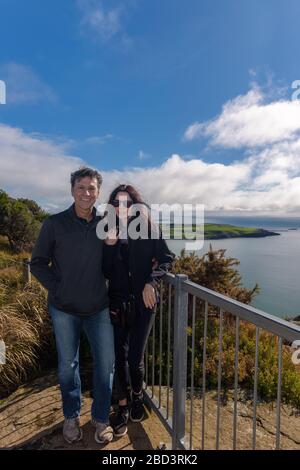 Touristenpaar in der Nähe des Aussichtsplatts auf der Nuss in der Stadt Stanley, Tasmanien mit Stanley Bay. Stockfoto