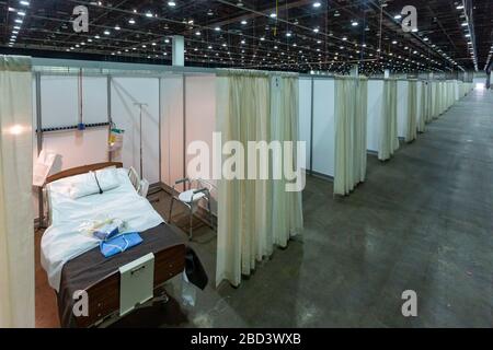 Detroit, Michigan, USA. April 2020. Arbeiter bauen ein Notarztkrankenhaus im TCF-Kongresszentrum auf. Das Krankenhaus mit 1.000 Betten wird Covid-19-Patienten versorgen. Kredit: Jim West/Alamy Live News Stockfoto