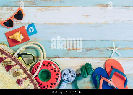 Reise- und Sommerhintergrundkonzept, Reisepass, Sonnenbrille, Hausschuhe, Seesterne und Accessoires auf altem blauen Holztisch in der Draufsicht mit Freiraum. Stockfoto