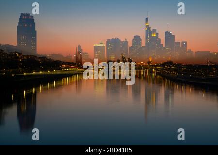 06. April 2020, Hessen, Frankfurt am Main: Die Bankensilhouette Frankfurts spiegelt sich im Wasser des Mains wider (mit Zoom-Effekt gedreht). Trotz frühlingsähnlicher Temperaturen sind die Straßen und Brücken der Stadt wegen der Bewegungseinschränkungen durch die Corona-Pandemie nicht sehr ausgelastet. Foto: Boris Roessler / dpa Stockfoto