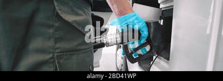 Gaspumpe Coronavirus Ausbruchschutzhandschuhe zum Berühren des Griffs beim Pumpen von Benzin an der Tankstelle Banner Panorama. Niedrige Rohölpreise fielen während der COVID-19-Pandemie. Stockfoto