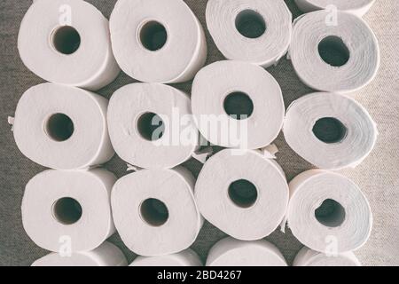 Toilettenpapier rollt den Hintergrund von oben flach auf viele offene Rollen. Hosten von Badezimmergeweben in Angst vor Versorgungsengpässen im Laden während des Coronavirus COVID-19 Panikkaufs. Stockfoto