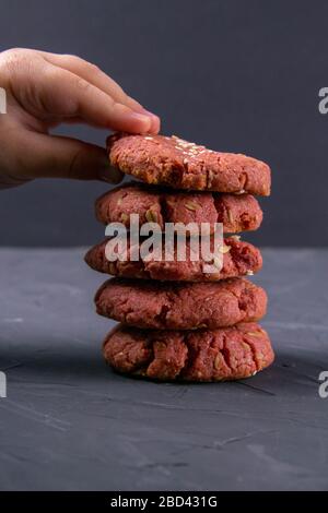 Die Hand des Kindes, das nach frisch gebackenen Rüben-Chip-Haferflocken auf einem Blecktisch greift. Feiertag- und Kochkonzept. Selektiver Fokus Stockfoto