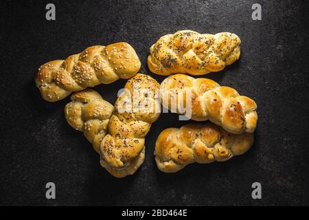 Leckere Flechtbrötchen auf schwarzem Küchentisch. Draufsicht. Stockfoto