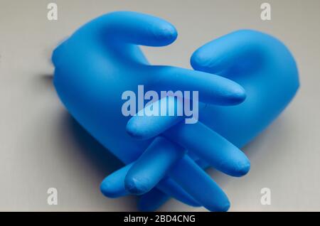 Aufgeblasene blaue medizinische Handschuhe. Ein Paar Schutzhandschuhe mit verschlossenen Fingern. Latexblaue Handschuhe auf Netzhintergrund. Selektiver Fokus. Nahaufnahme. Stockfoto