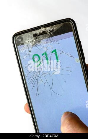 Kaputtes Telefon in der Hand. Hand-Handgerät mit Notrufnummer 911. Notruf und Dringlichkeit: Wählen Sie auf dem Smartphone-Bildschirm die Notrufnummer. Draufsicht an einem Angl Stockfoto