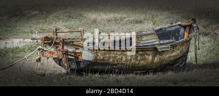 Das zerstörte Boot sitzt auf dem müde aufradenen Flussbett Stockfoto