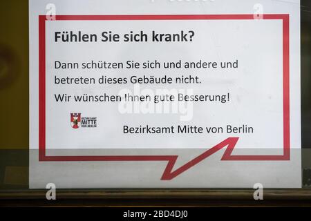 Berlin, Deutschland. April 2020. Am Eingang zum Bezirksamt Mitte mit dem Geschäftsamt Mitte in der Parochialstraße ist eine Mitteilung hängen geblieben. In der Notiz wird die Frage "fühlen Sie sich krank?" gestellt. In diesem Fall sollte das Gebäude nicht betreten werden. Kredit: Jens Kalaene / dpa-Zentralbild / ZB / dpa / Alamy Live News Stockfoto