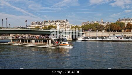 Ein Flussboot voller Touristen, das auf der seine im Zentrum von Paris unterwegs ist. Stockfoto