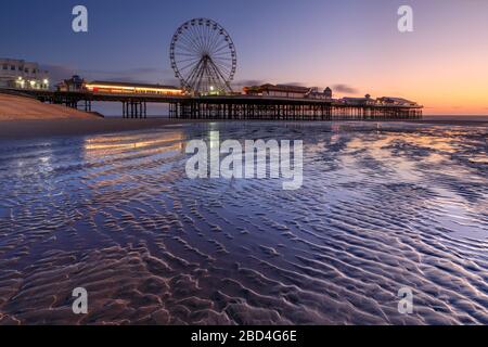 Der Central Pier in Blackpool wurde während der Dämmerung vom Strand aus eingefangen. Stockfoto