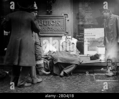 Feuerwehrmann saß auf dem Bürgersteig, nachdem er einen Brand in einem U-Bahn-Tunnel in New York City bekämpft hatte, der in der Nähe der West 55th Street und des Broadway am 6. Januar 1915 stattfand Stockfoto