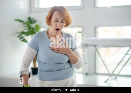 Fröhlich rothaarige Frau mit gesundheitlichen Problemen Stockfoto