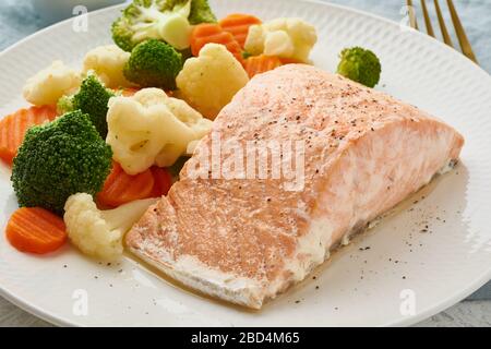Dampflachs und Gemüse, Paleo, Keto, Fodmap, DASH-Diät. Mediterrane Ernährung mit gedämpftem Gemüse Stockfoto