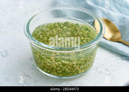 Einweichen von grünem Erbsengetreide in Wasser zum Gären von Getreide und zur Neutralisierung von Phytsäure. Stockfoto