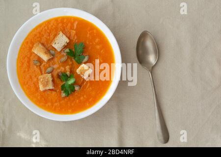 Kürbis- und Karottensuppe mit Samen, Crackern und Petersilie. Vegetarische Suppe. Stockfoto