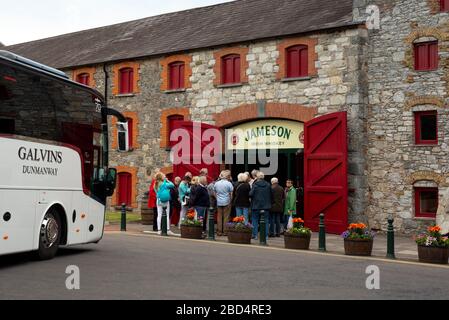 Jameson Destillerie Irland und eine Gruppe von Touristen am Eingang der Old Jameson Whiskey Distillery in Midleton County Cork Irland für die geführte Jameson Experience Tour als eine der berühmtesten und beliebtesten Touristenattraktionen in East Cork Irland, Cork Midleton Distillery Stockfoto