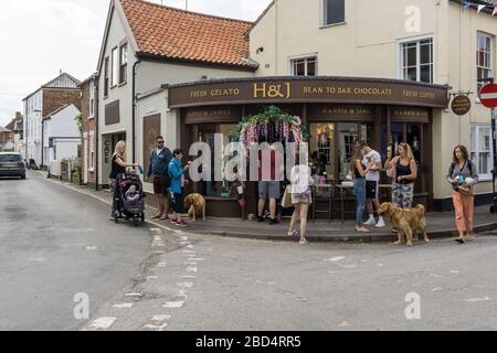 Besucher außerhalb des beliebten H&J Eisdielen im Badeort Southwold, Großbritannien Stockfoto