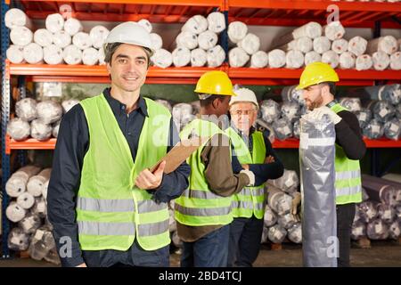 Das Team der Lagerarbeiter arbeitet in einem Werks-Teppich-Laden zusammen Stockfoto