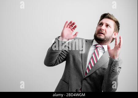 Porträt des Geschäftsmanns tragen Business-Kleidung machen unheimlich Geste isoliert auf grauem Hintergrund mit Kopie Raum Werbebereich Stockfoto