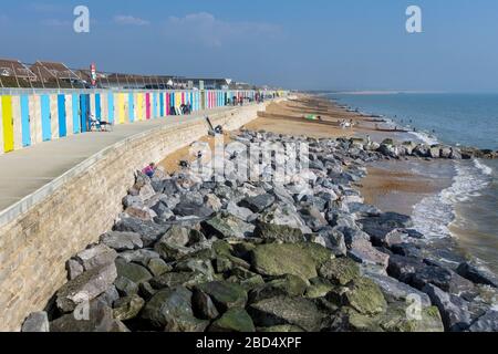 Betonstrandhütten, die in die neue Küstenmauer von Milford-on-Sea gebaut wurden, um einem 1:200-jährigen Sturm standzuhalten. Stockfoto