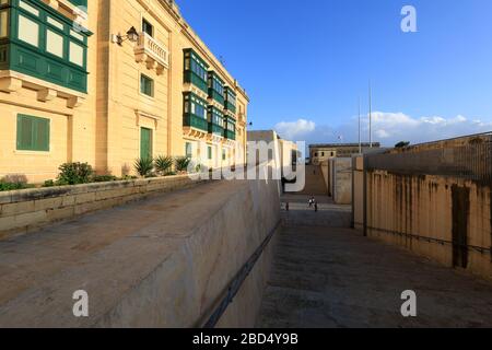 Wohnhäuser auf der Oberseite der Befestigungsanlagen sowie die Treppe zum Stadttor von Valletta, Malta Stockfoto