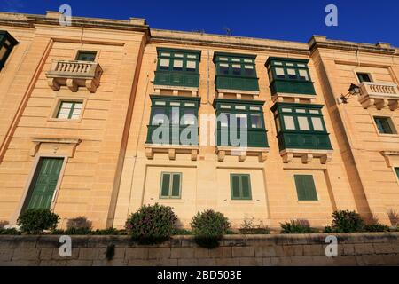 Außenansicht der neu renovierten Wohnhäuser auf der Spitze der Befestigungsanlagen von Valletta, Malta, neben dem berühmten Stadttor Stockfoto